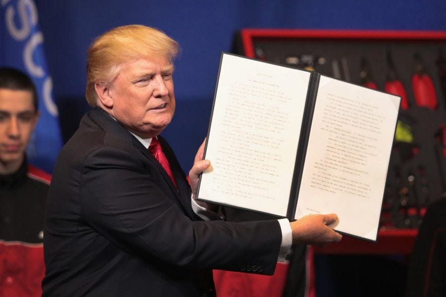 Donald Trump showing off latest immigration crackdown signed bill.