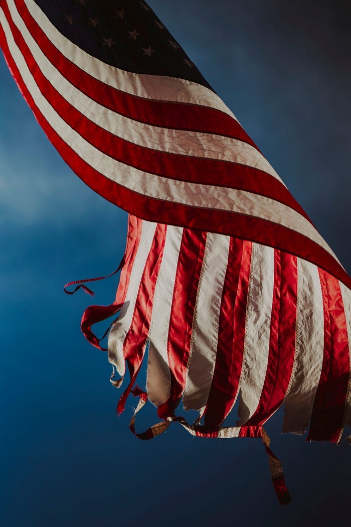 A tattered American flag blows in the wind.