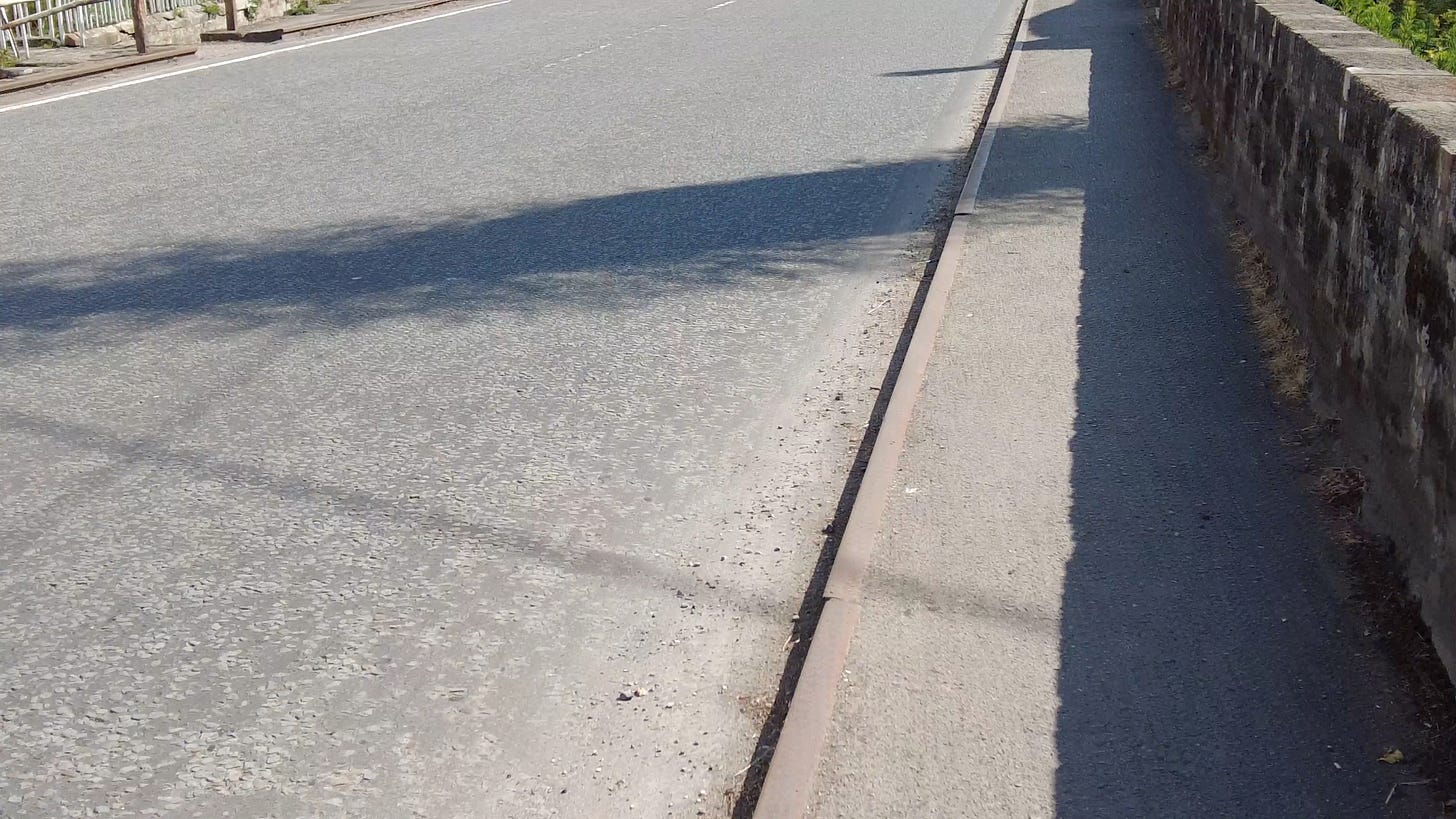Old railway tracks make good kerbs on the footpath in Shrewton, Wiltshire. Image: Roland Millward