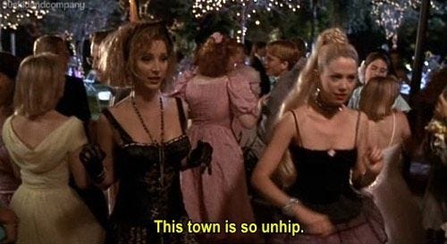 ̗̀Screenshot of Romy and Michele at their 1987 prom, both dressed like Madonna, saying "This town is so unhip"