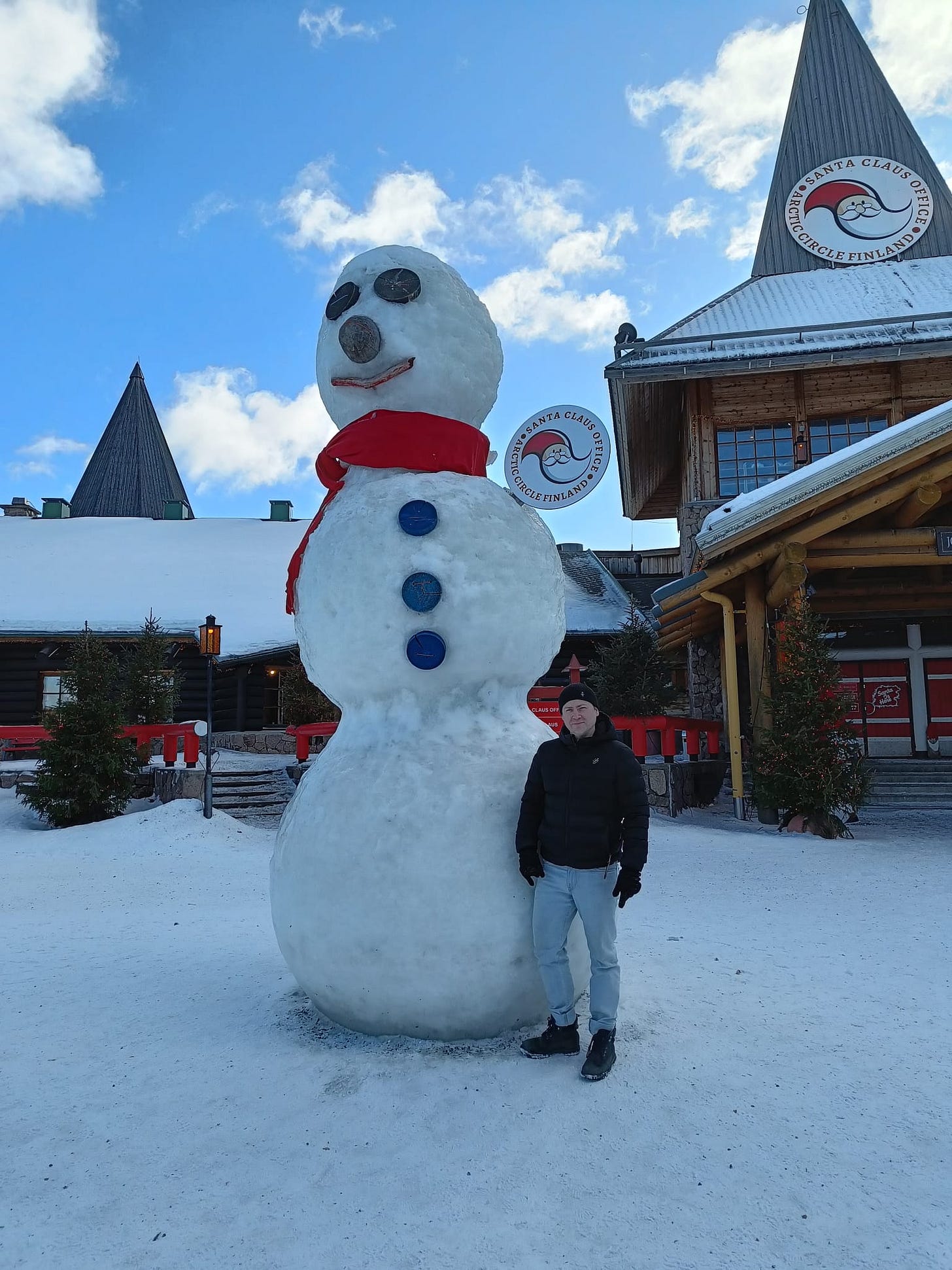 A man poses next to a giant snowman