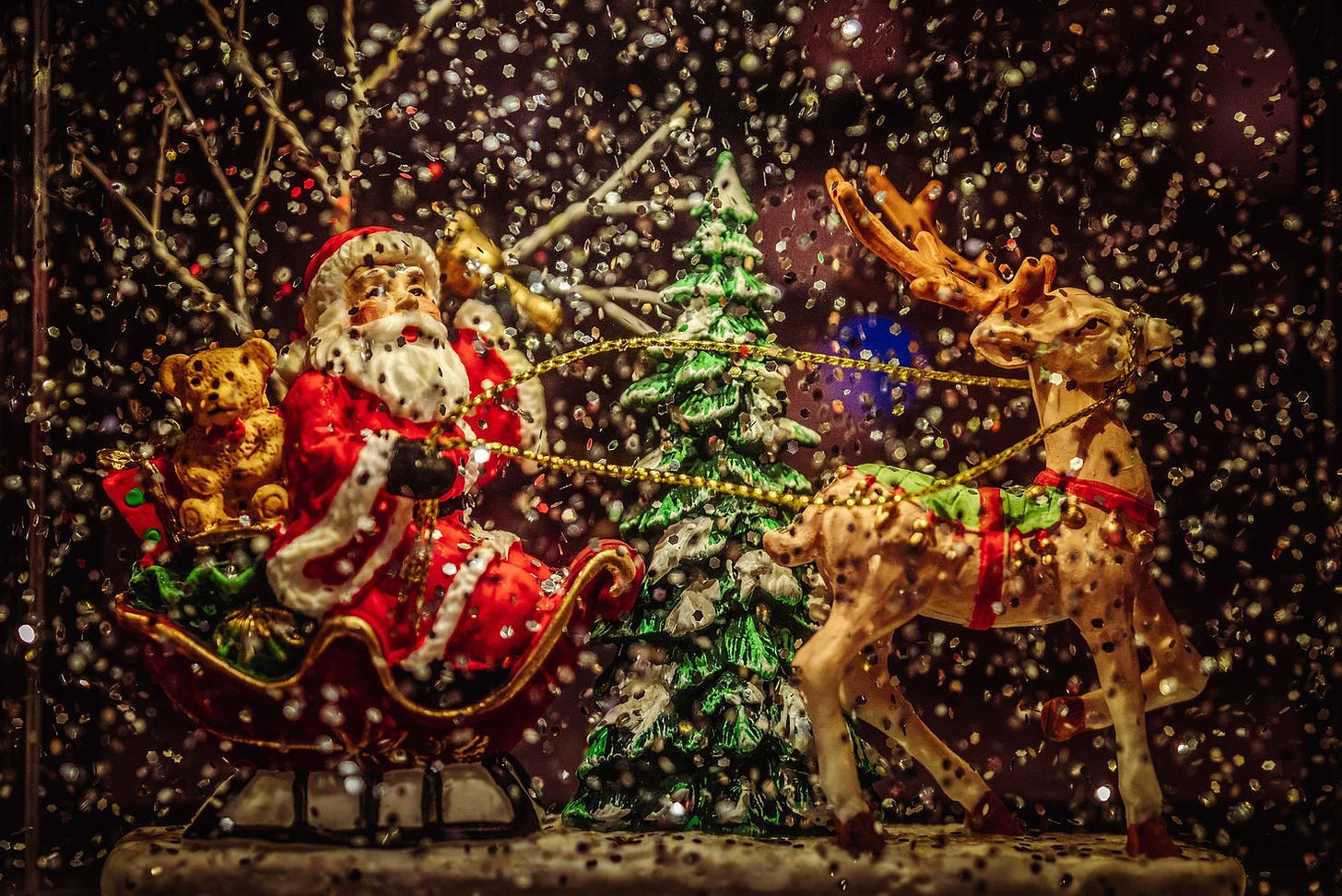 A colorful image of Santa in a sleigh, pulled by reindeer.