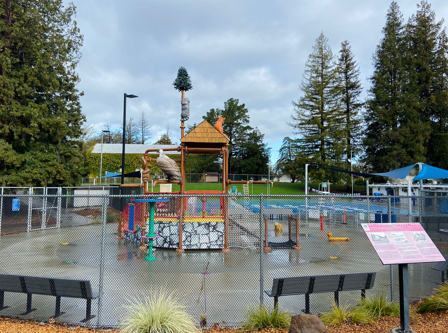 A park splash pad structure with animal figure decorations.