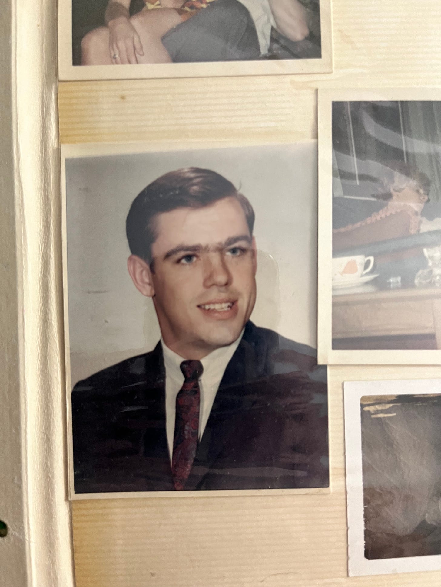 a young man in a suit and tie with dark hair and a gentle smile