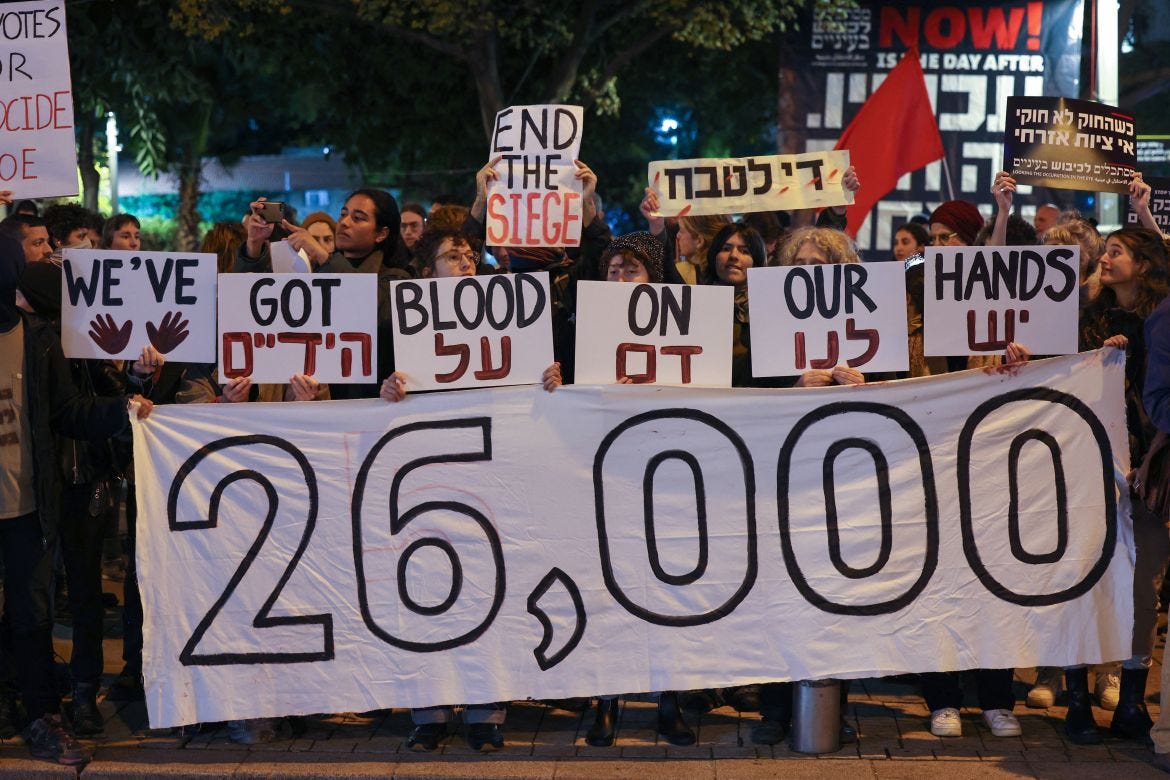 Israeli left-wing activists lift placards during a protest against the war in Gaza outside the Ministry of Defence in the central city of Tel Aviv on January 27