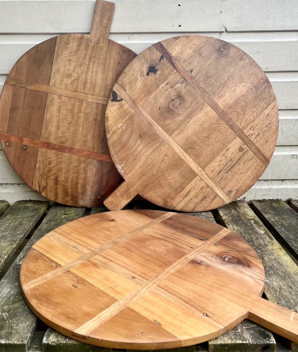 a collection of three circular wooden serving boards