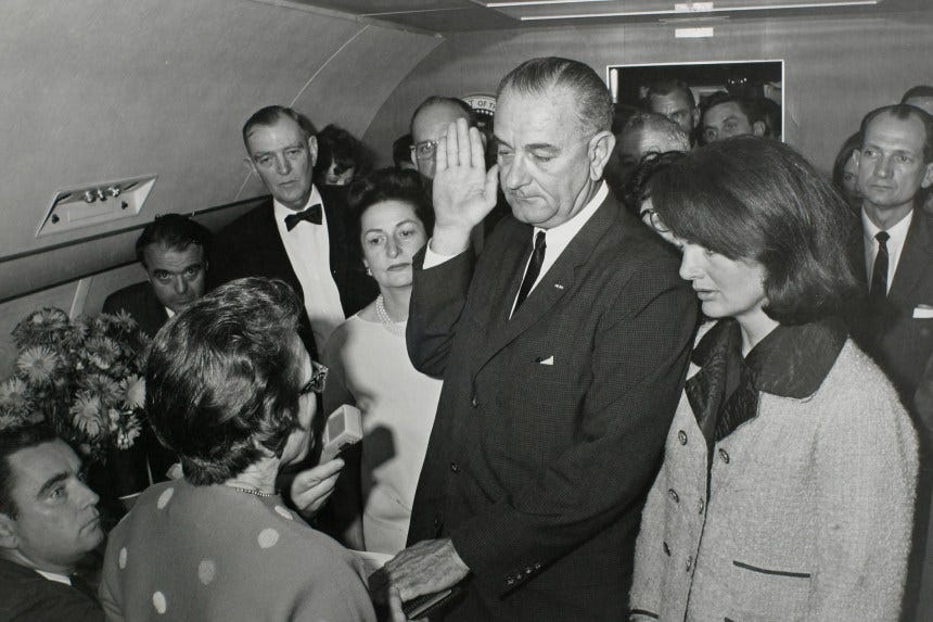 Jackie Kennedy stands beside Lyndon Johnson as he takes the oath of office after the death of her husband