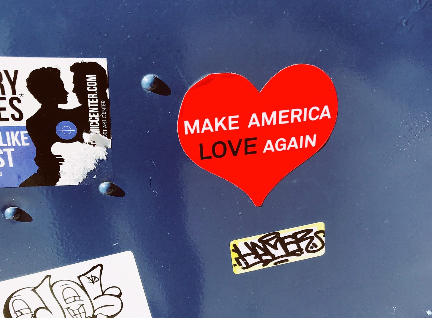 Photo of mailbox with a red heart-shaped sticker that says "Make America Love Again."