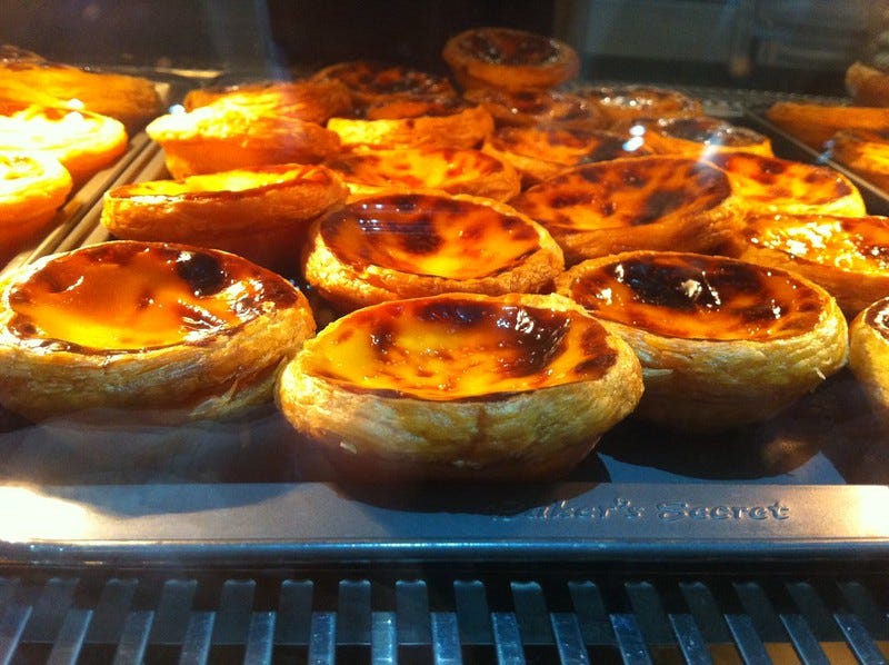 a close up of a tray of custard tarts baking in an oven