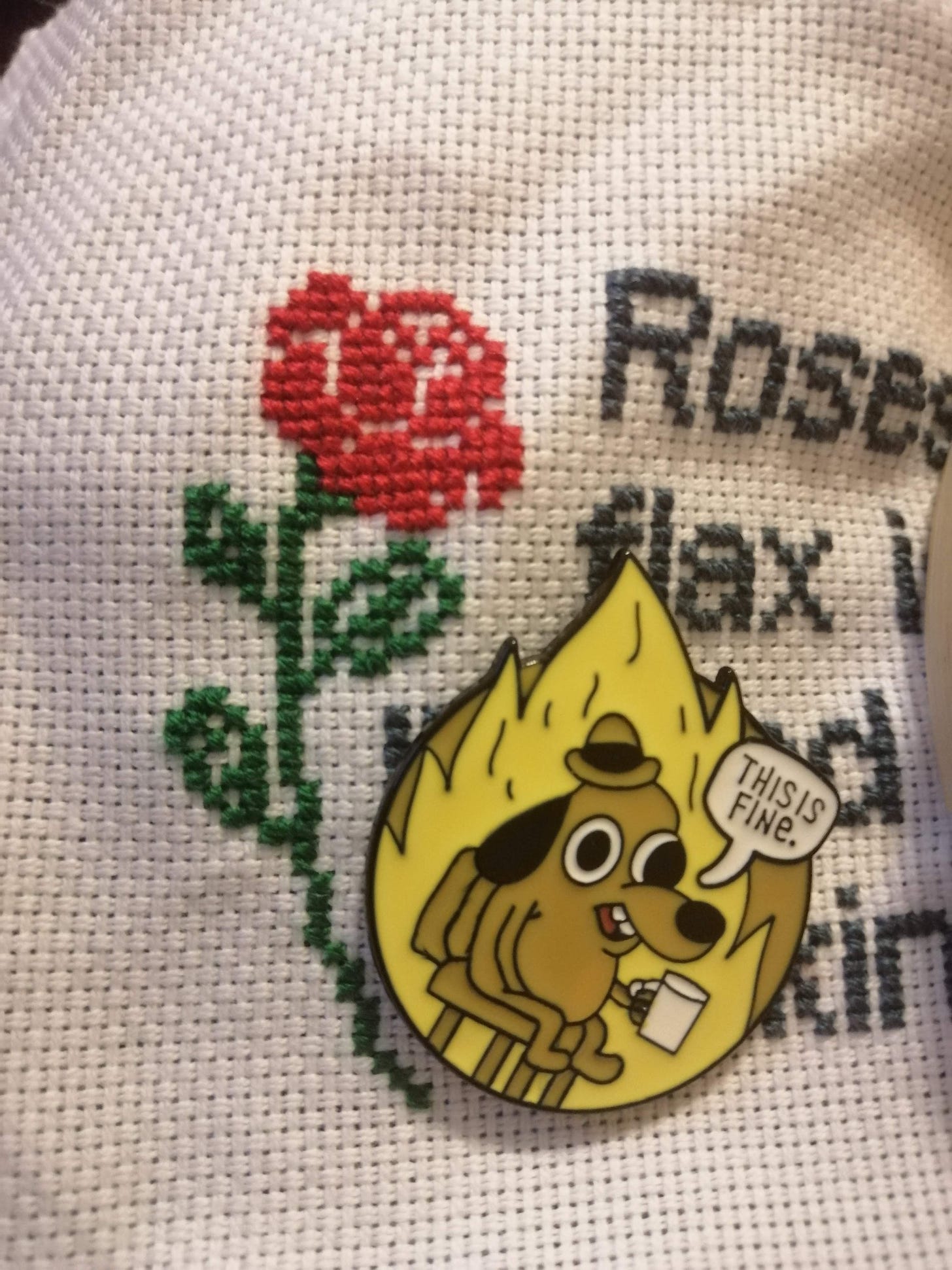 Close up of the above stitch in progress with a needle minder with the dog in the house on fire "This is fine" meme