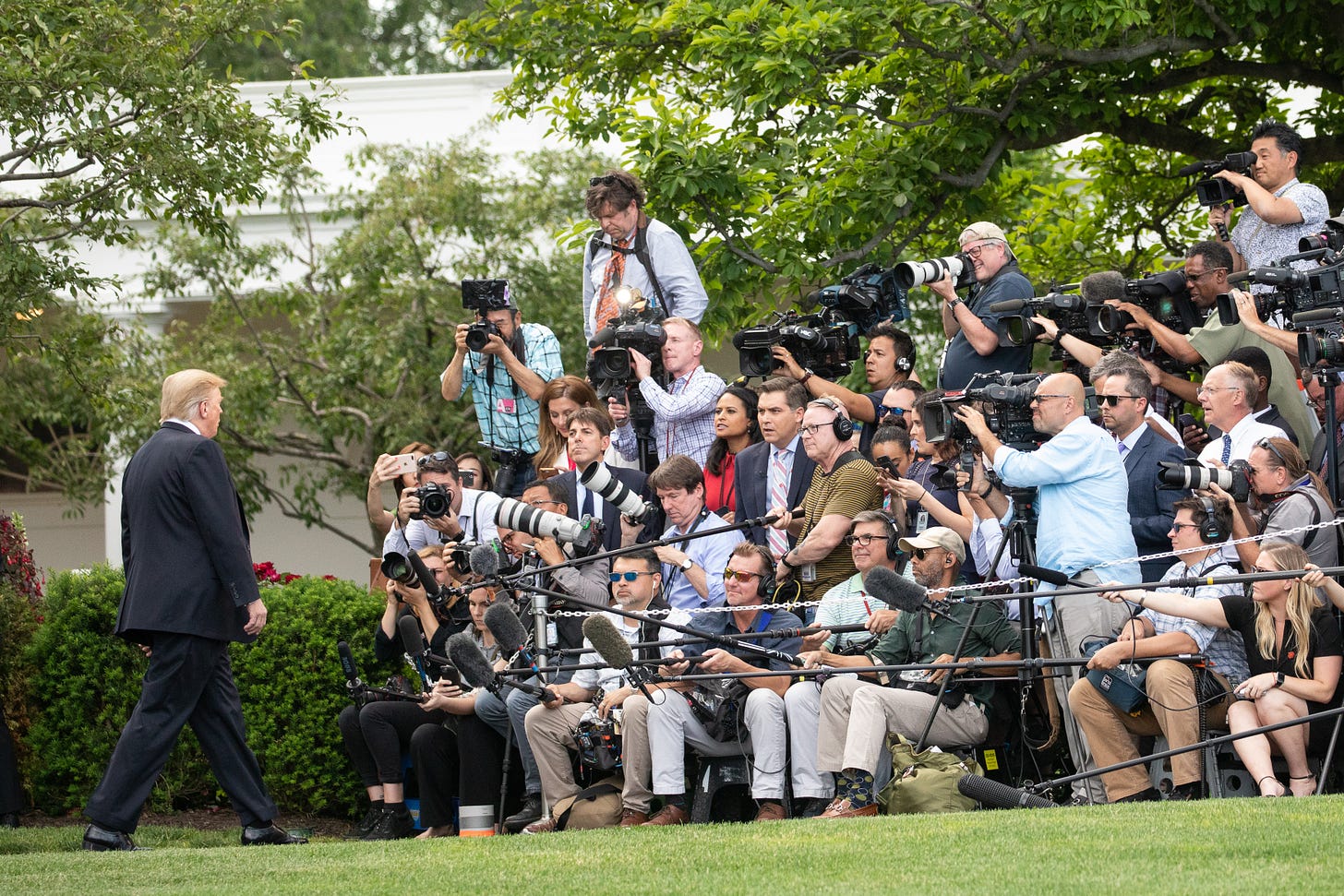 A photo of Donald Trump speaking to the dozens of members of the press on the South Lawn of the White House on May 20, 2019.