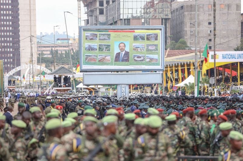 A portrait of Cameroon's president, Paul Biya, is seen as soldiers prepare ahead of a parade marking the 51st celebration of Unity Day in Yaounde.