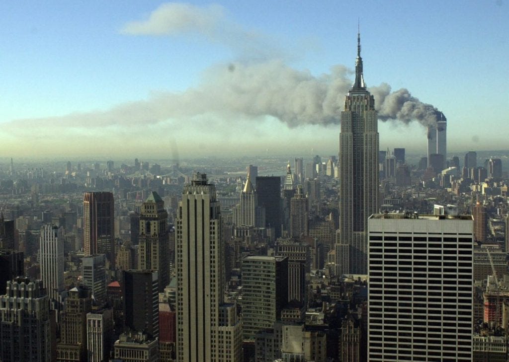 Plumes of smoke pour from the World Trade Center buildings in New York Tuesday, Sept. 11, 2001. Planes crashed into the upper floors of both World Trade Center towers minutes apart Tuesday in a horrific scene of explosions and fires that left gaping holes in the 110-story buildings. (AP Photo/Patrick Sison)