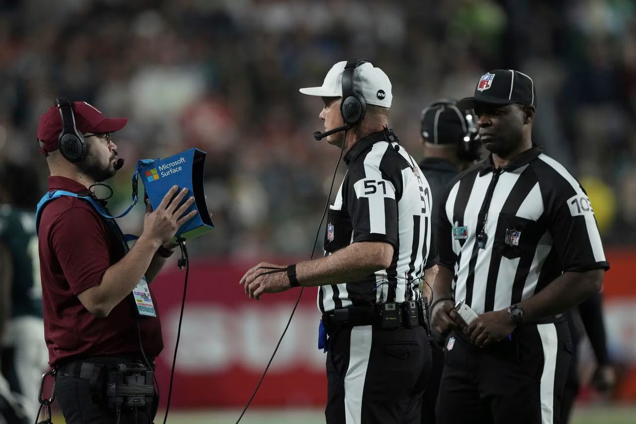 Referees reviewing a play, about to be hated by half the country.