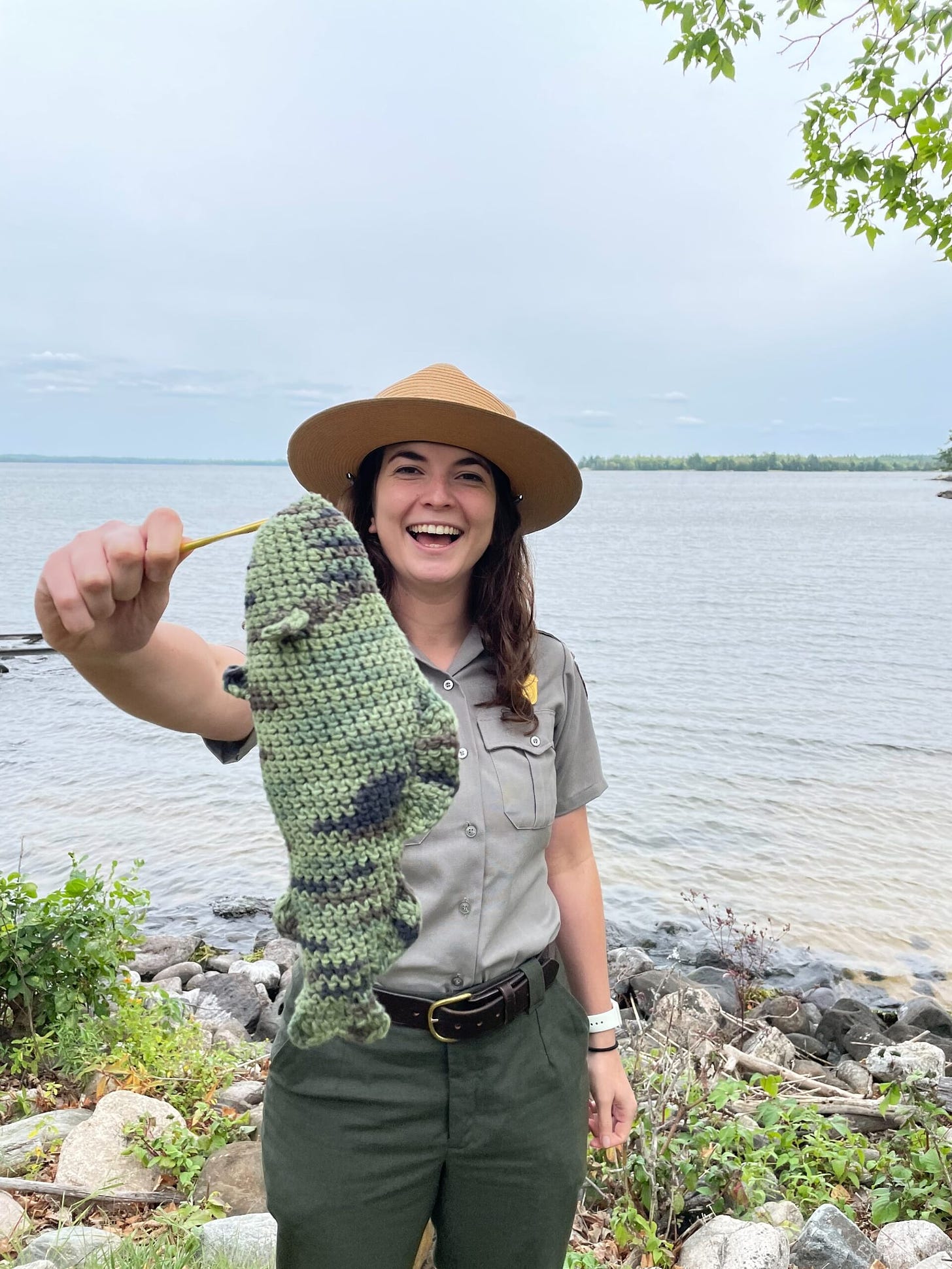 A photo of ranger Hailey Burley holding a crocheted walleye