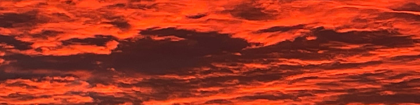 Closeup of vivid orange-red and maroon clouds at sunrise