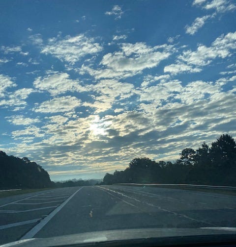 layers of clouds and blue sky sunrise over highway