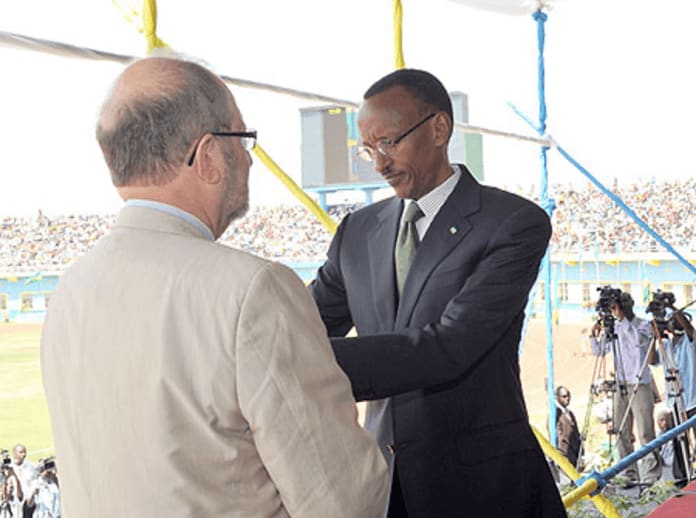 A person in suit shaking hands with another person Description automatically generated