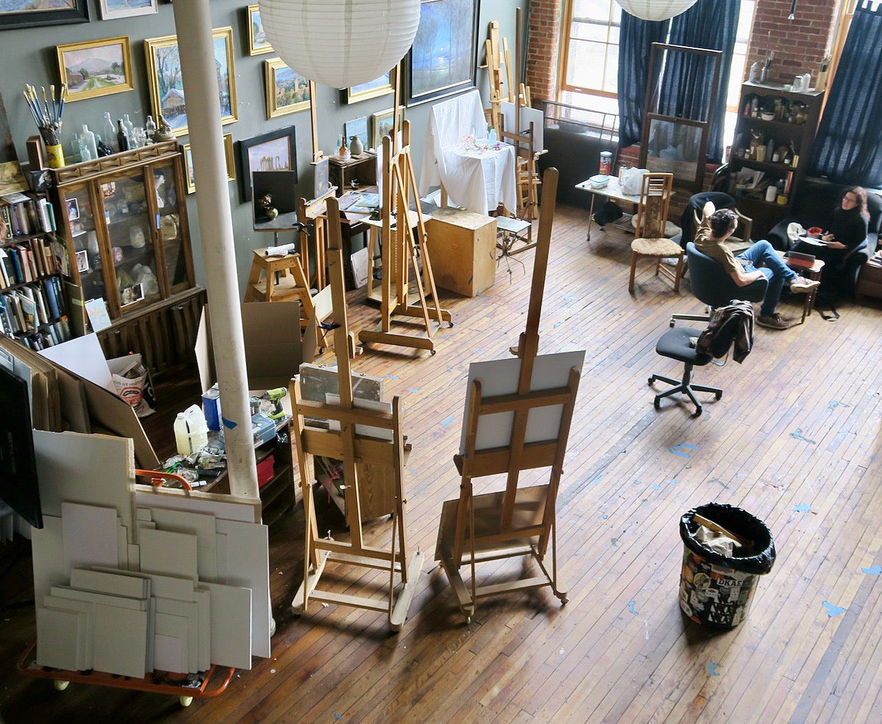 An art studio with easels and a person sitting in a chair

Description automatically generated