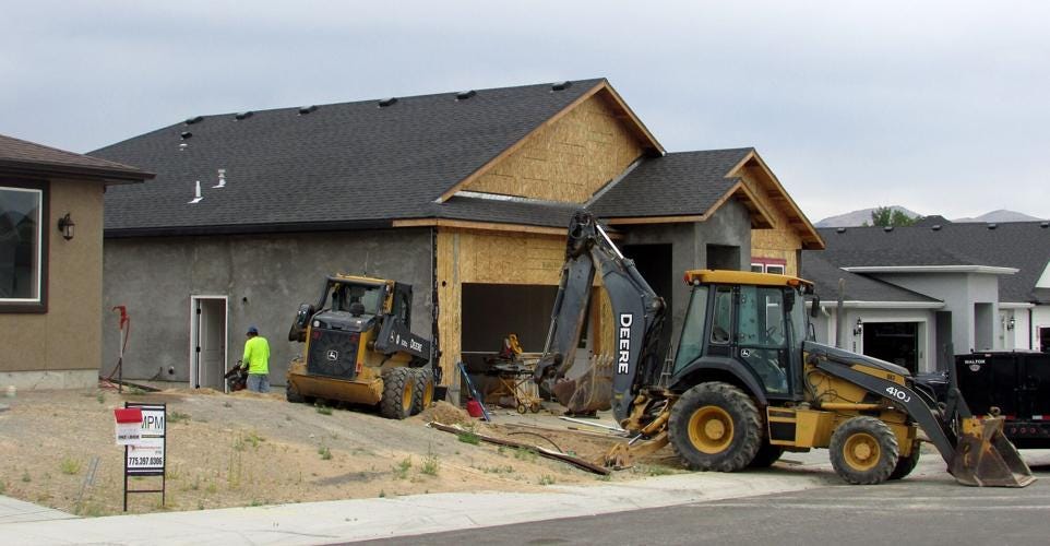 New home under construction in Elko, Nevada. Photo shows workers and construction equipment.