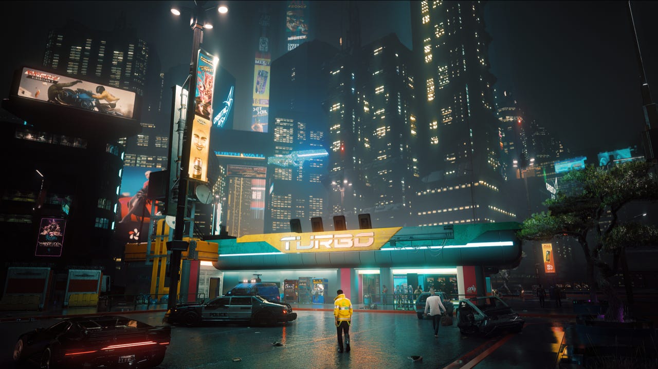 Neon-lit skyscrapers with a man standing below them