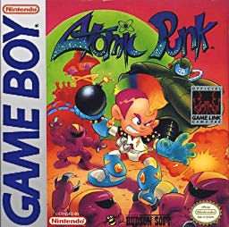 The cover of Atomic Punk, a Game Boy Bomberman game featuring... well, Bomberman. But the cover art has a robot boy with a rainbow mohawk on it instead.