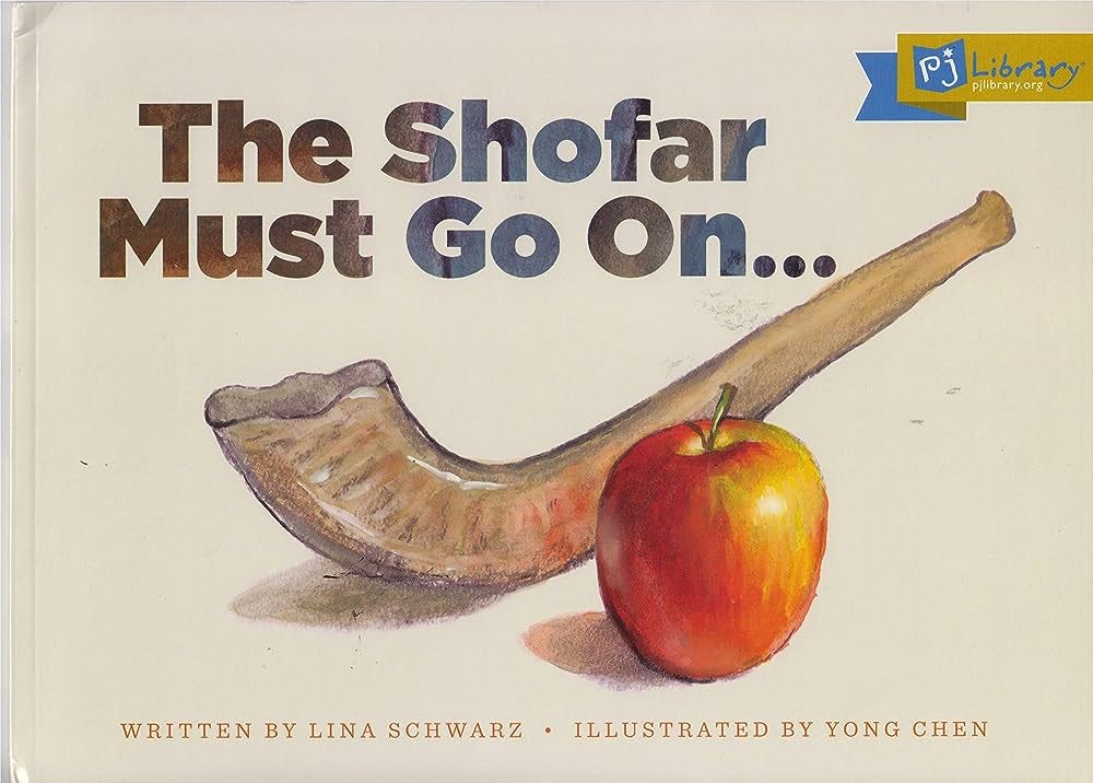 The book over features a shofar and red apple