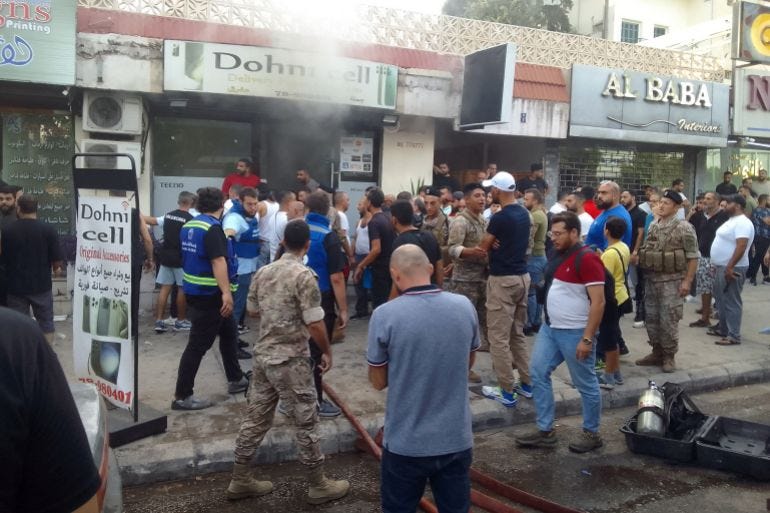 Persone e soccorritori si radunano sulla scena di una segnalata esplosione di un dispositivo a Saida, nel Libano meridionale