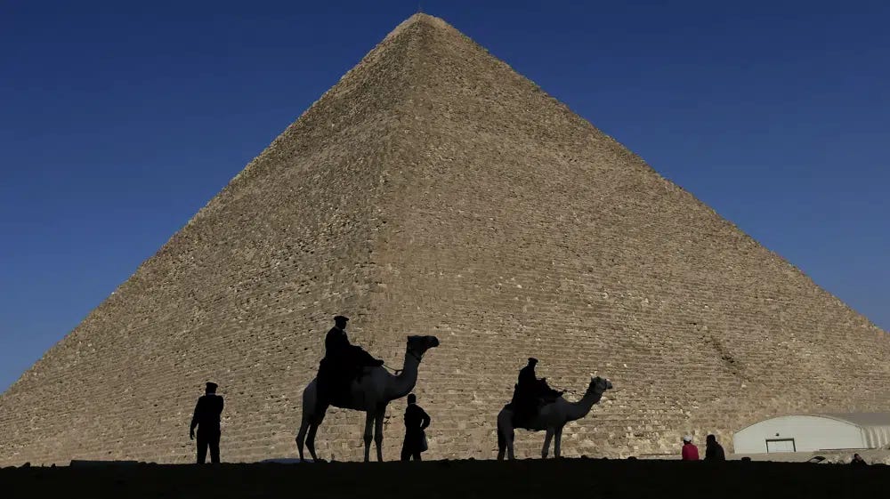 FILE - Policemen are silhouetted against the Great Pyramid in Giza, Egypt, Dec 12, 2012. Egypt unveiled on Thursday, March 2, 2023, the discovery of a 9-meter-long chamber inside the Great Pyramid of Giza, the first to be found on the structure’s north side. (AP Photo/Hassan Ammar, File)