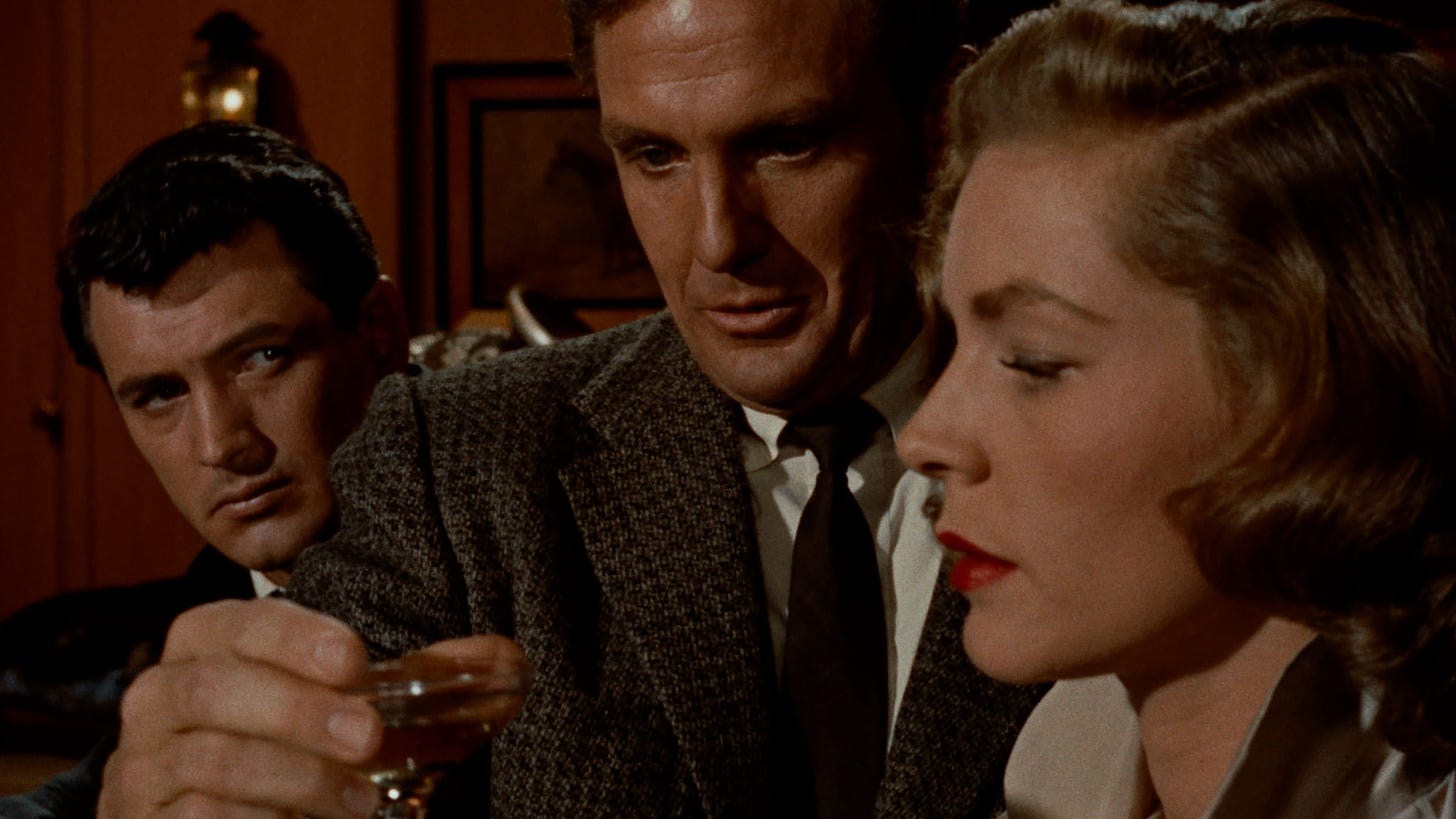 Rock Hudson, Robert Stack and Lauren bacall in tight close-up as Stack contempkates another drink.