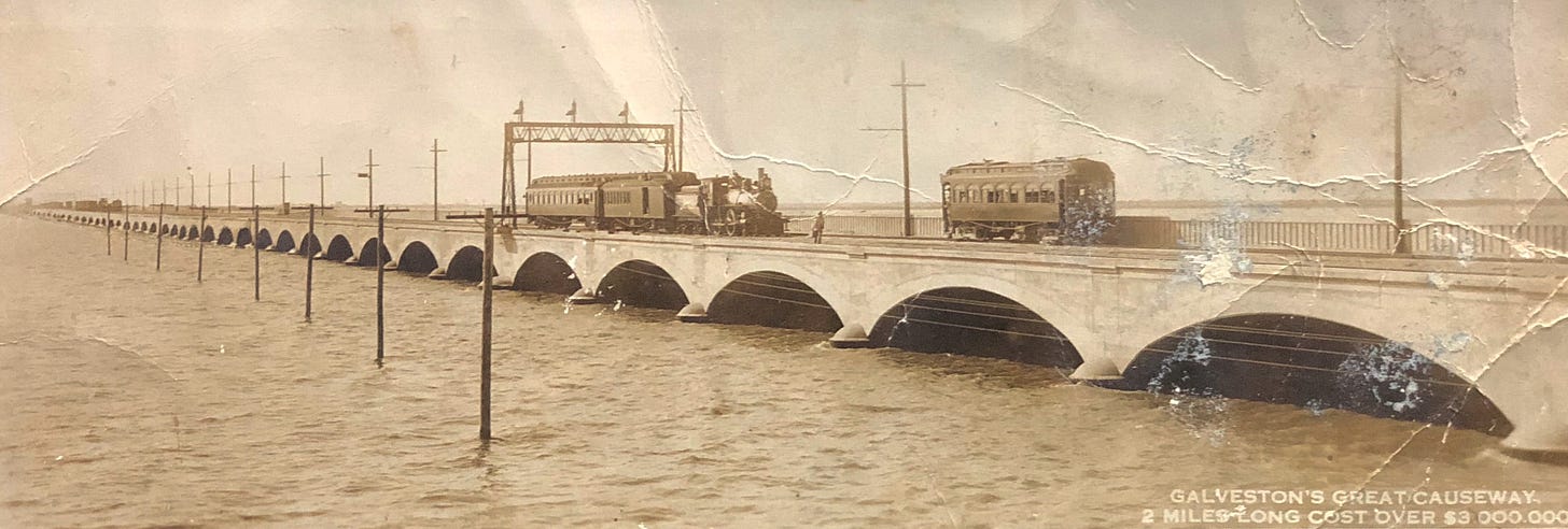 A 1920’s postcard,sepia colored and wrinkled, of the Galveston, Texas Causeway with a train and cable car.