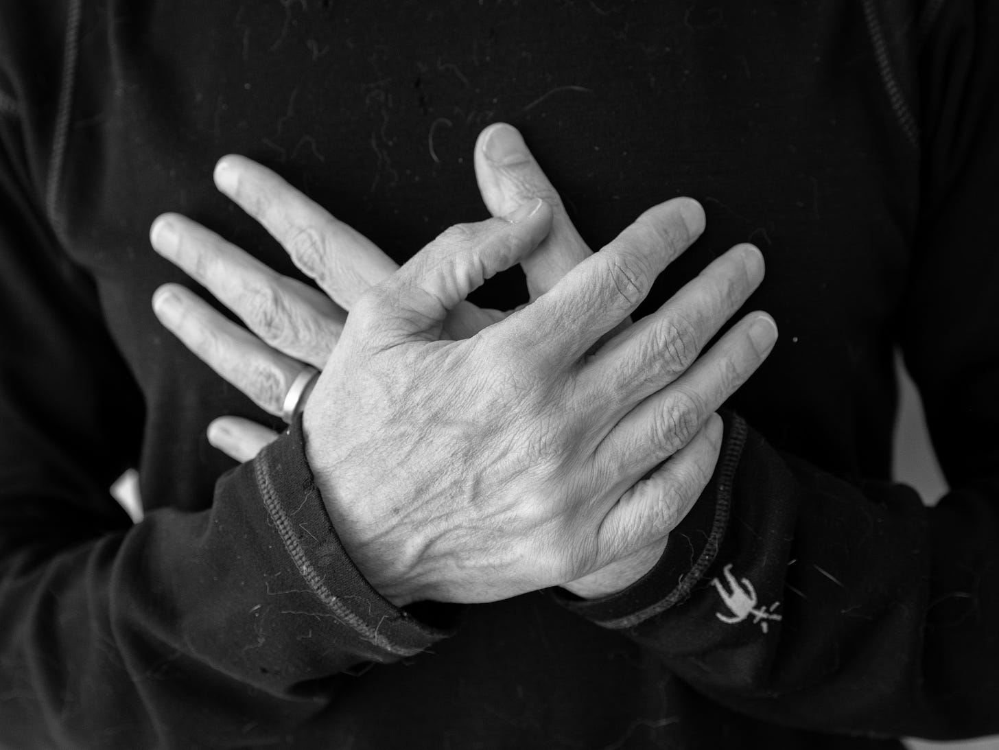 Randy with open palms crossed over his heart in black and white