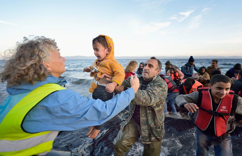 Volunteers carry a child ashore on a beach near Molyvos, on the Greek island of Lesbos, on October 30, 2015, after a group of refugees crossed the Aegean Sea from Turkey in a small overcrowded boat provided by Turkish traffickers to whom the refugees paid huge sums. The refugees were received in Greece by local and international volunteers, then proceeded on their way toward western Europe. Under "informed consent" rules, the volunteers would have to give their written permission for this to be used, and the parents or legal guardianw of the two children would also have to agree and sign a release. The photographer would have had to produce the forms for their signature while they were busy getting out of cold wet clothes and into dry clothing and continuing their journey. Photo by Paul Jeffrey. Volunteers carry a child ashore on a beach near Molyvos, on the Greek island of Lesbos, on October 30, 2015, after a group of refugees crossed the Aegean Sea from Turkey in a small overcrowded boat provided by Turkish traffickers to whom the refugees paid huge sums. The refugees were received in Greece by local and international volunteers, then proceeded on their way toward western Europe. Under "informed consent" rules, the volunteers would have to give their written permission for this to be used, and the parents or legal guardianw of the two children would also have to agree and sign a release. The photographer would have had to produce the forms for their signature while they were busy getting out of cold wet clothes and into dry clothing and continuing their journey. Photo by Paul Jeffrey.