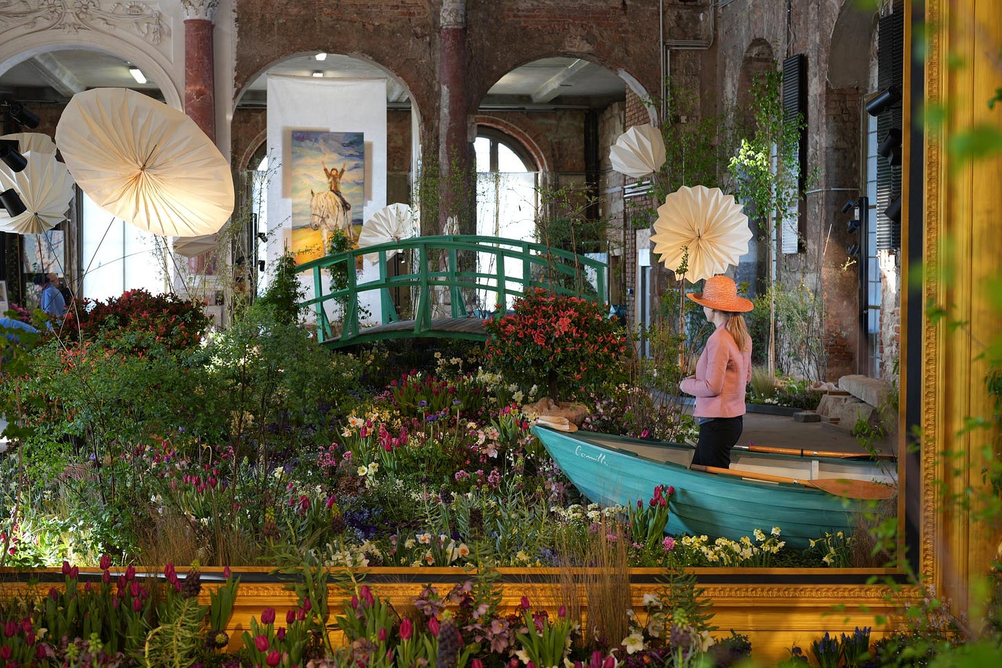 Monet's Water Lily Pond recreated life-size with flowers and a model in a boat.