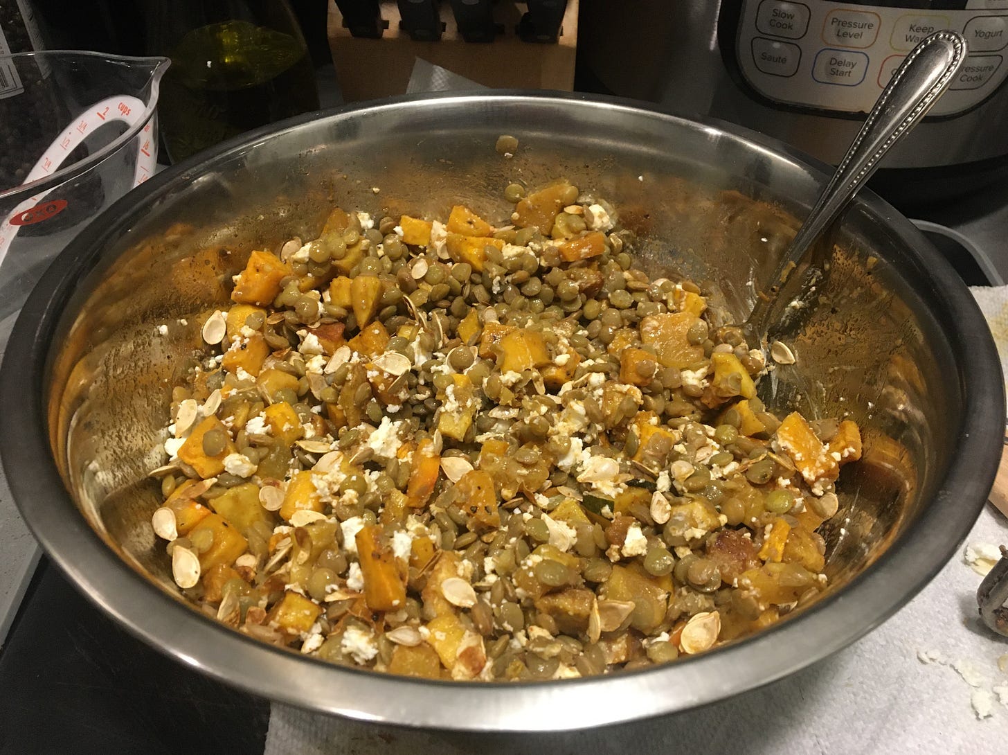 silver mixing bowl of squash lentil salad