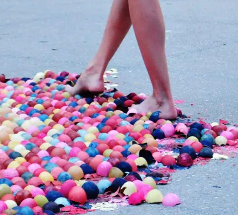 Image of a person walking on colored eggs, some of which are smashed