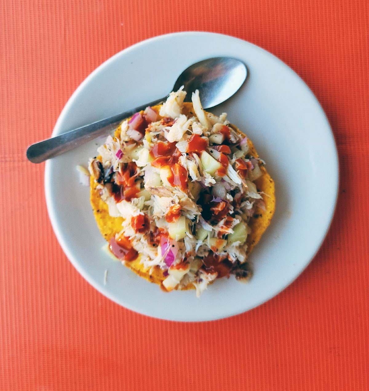 A crab tostada on a plate. 