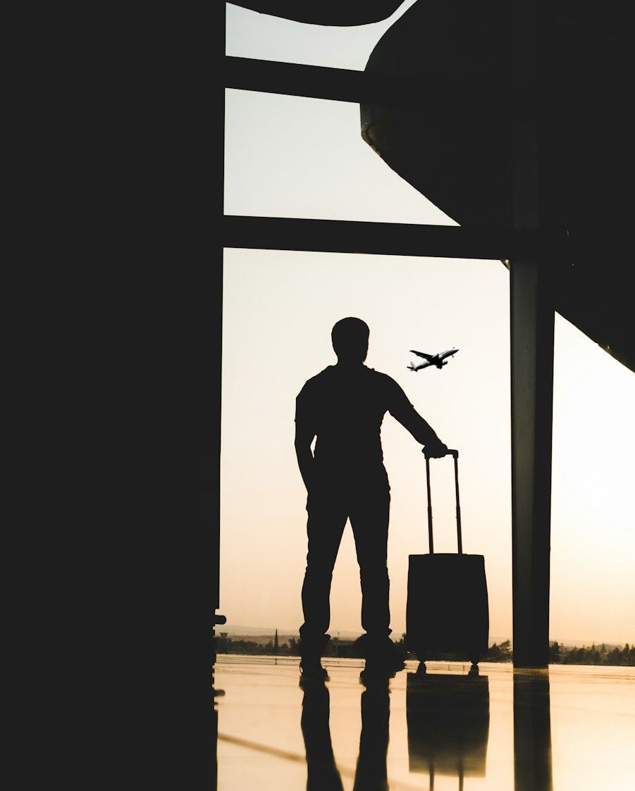 silhouette of man holding luggage inside airport silhouette of man holding luggage inside airport