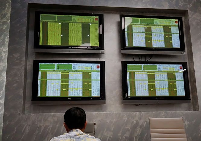 Screens showing stock board information at a securities company in Hanoi, Vietnam