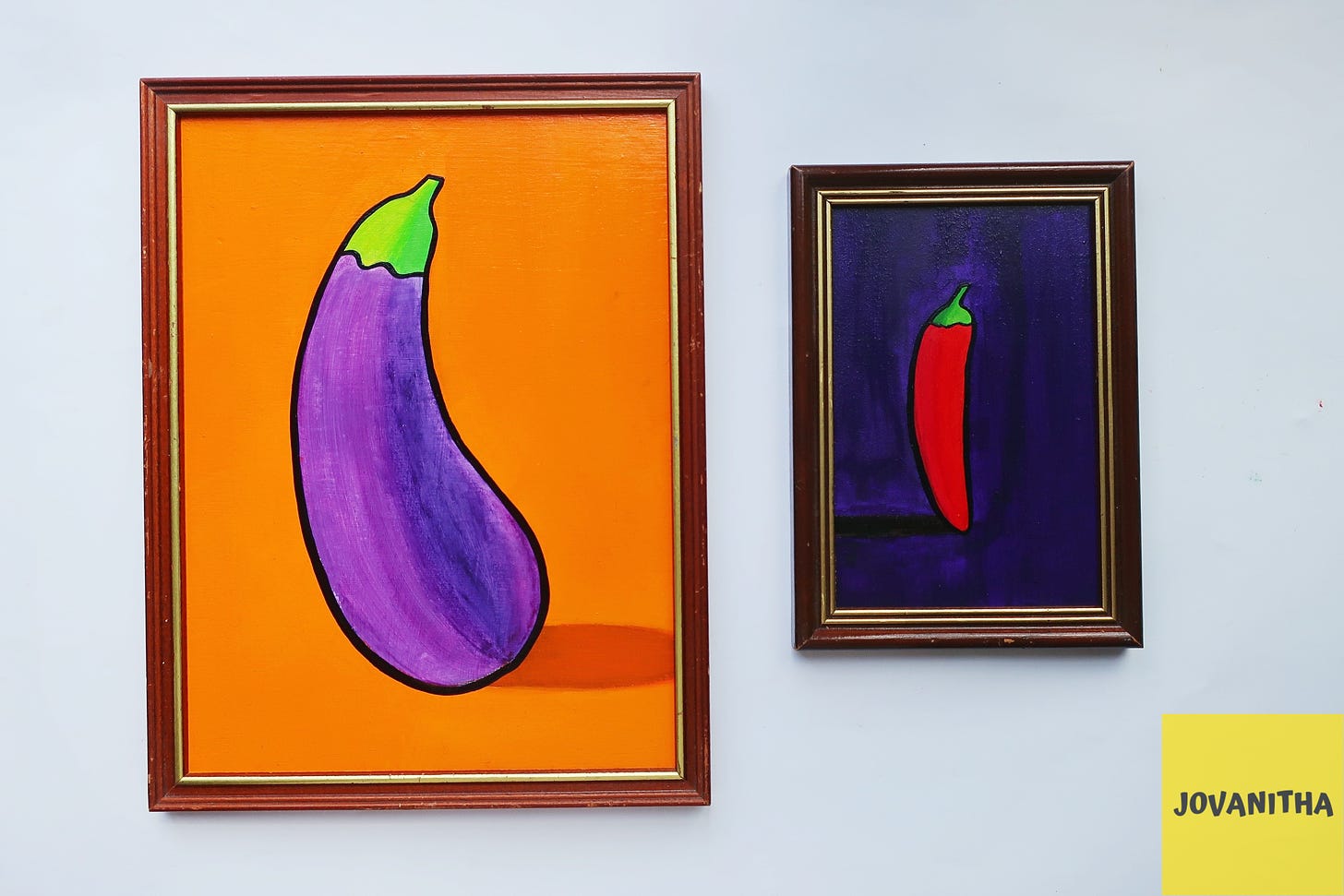 A purple eggplant on an orange background and a red chili on a purple background in vintage frames
