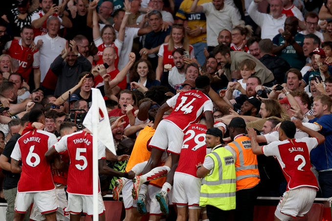 The Arsenal players celebrate with the supporters after Gabriel Martinelli's winner.