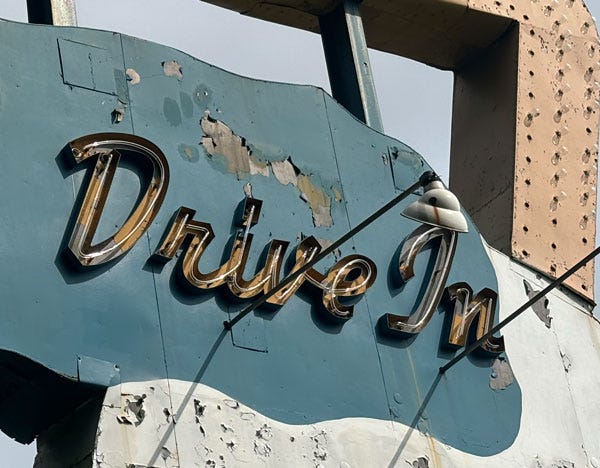 A closer shot of just the word "Drive-In" on the sign, with metal patches and peeling paint very obvious.