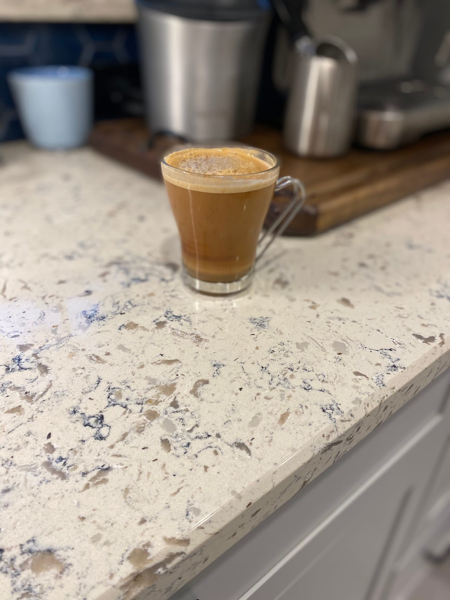 Clear glass cup with coffee on stone countertop