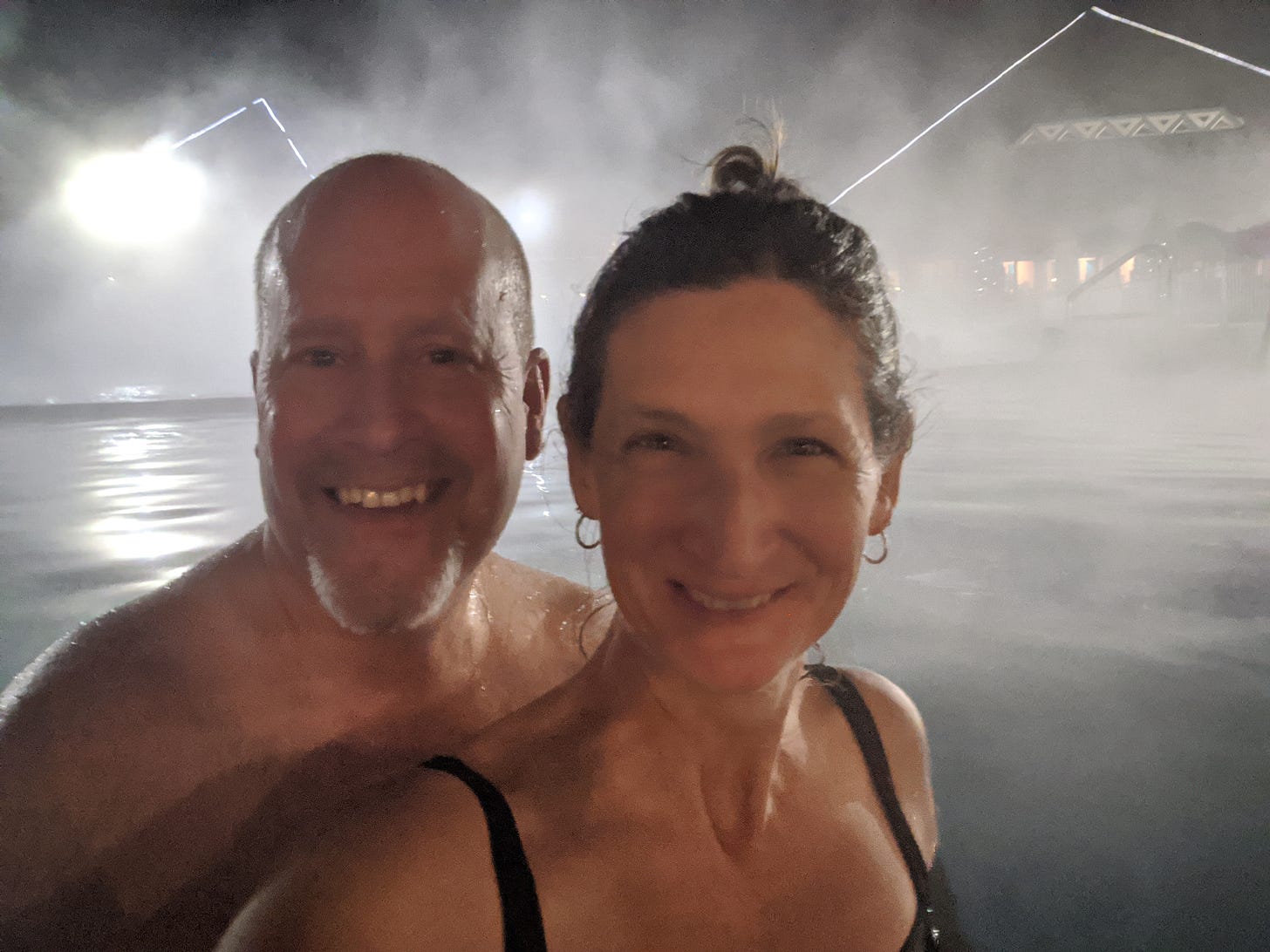 Andy and Sherry in swimsuits in a pool shrouded by fog at night