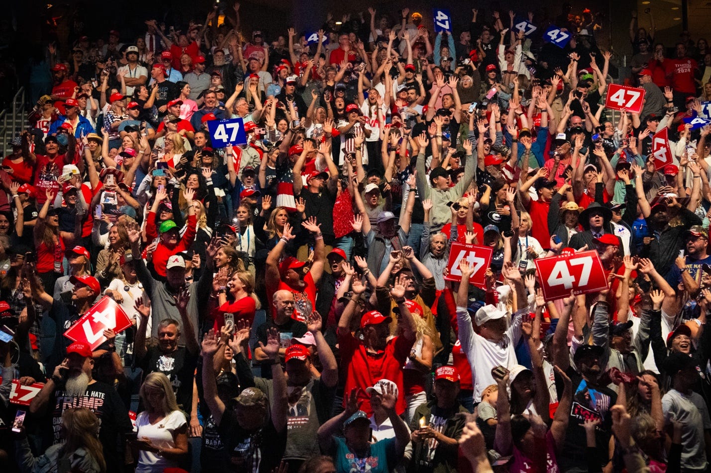 A large crowd of people raising their hands

Description automatically generated