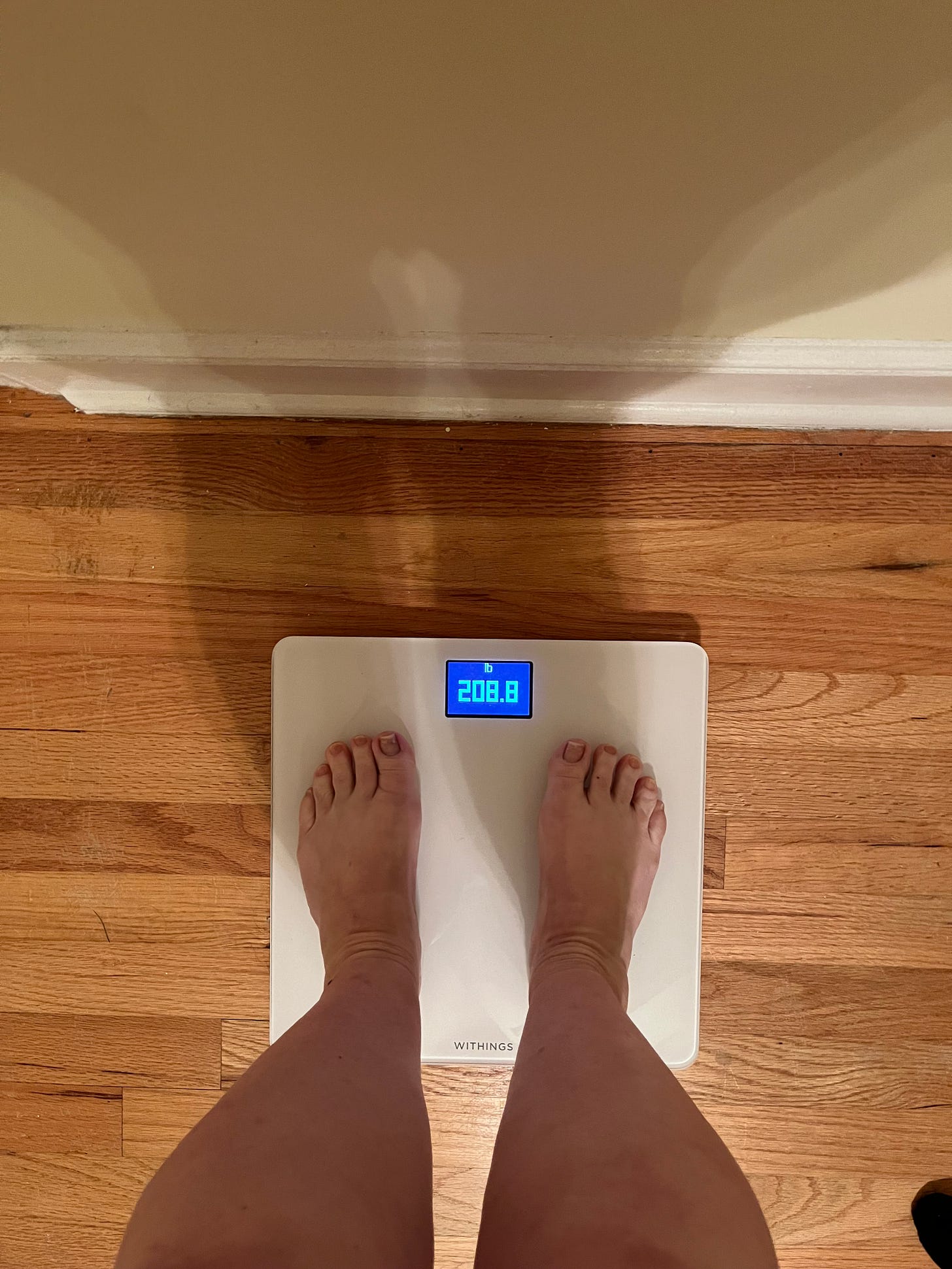 Picture of woman on a scale, weighing 208.8 pounds