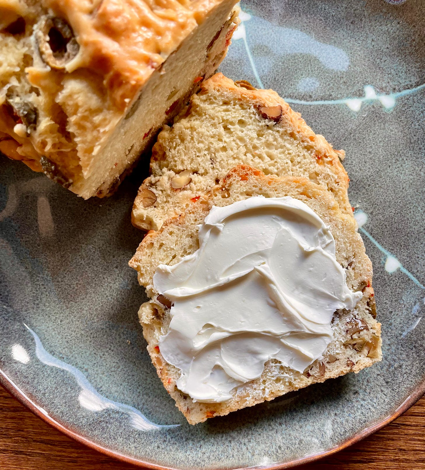 slice of olive bread smeared with cream cheese