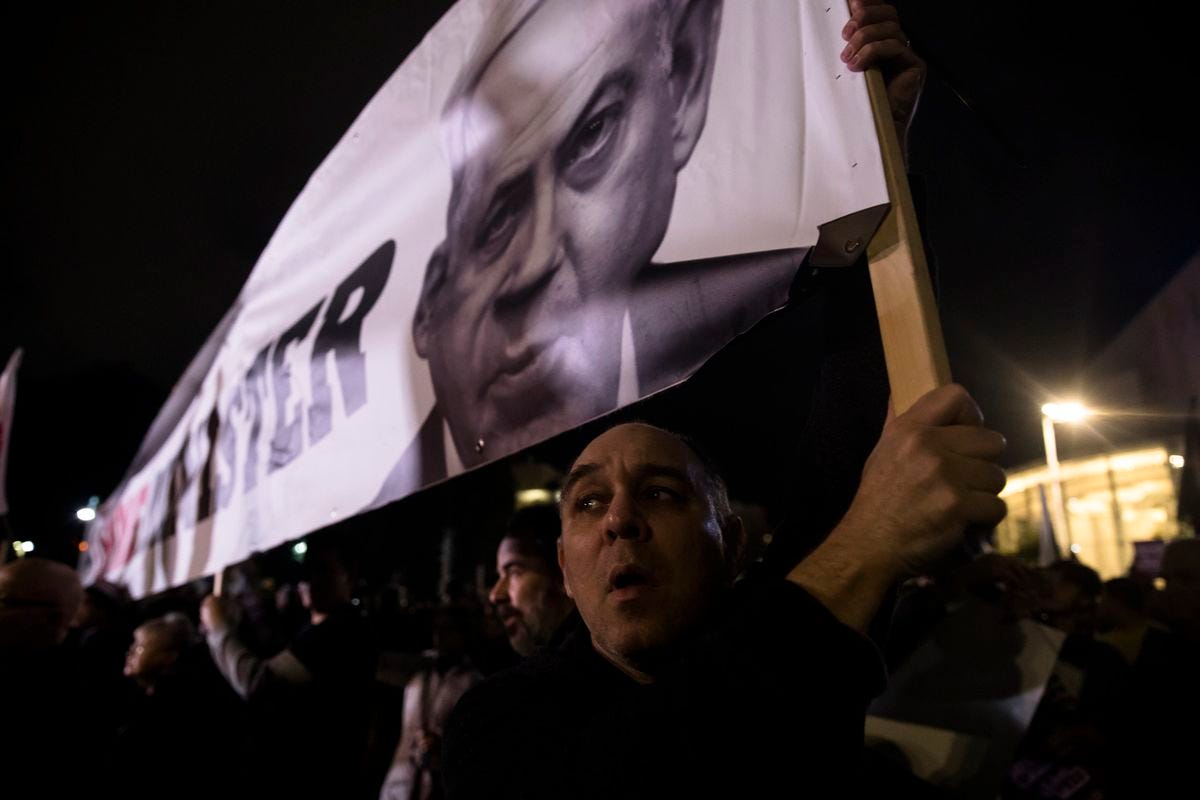 A protester holds a placard with a photo of Israeli Prime Minister Benjamin Netanyahu as he protests against the Israeli government’s plan for dramatic justice reform on January 8, 2023, in Tel Aviv, Israel.&nbsp;