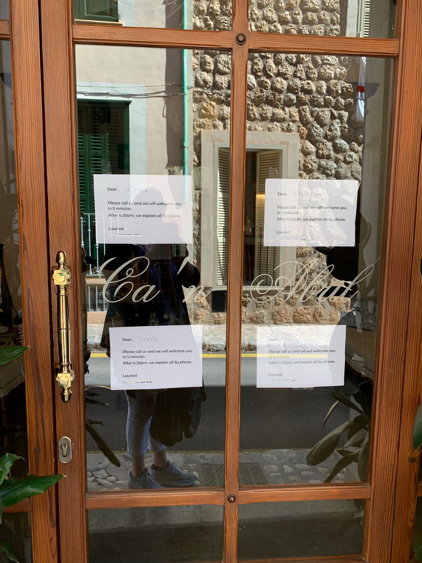 A hotel door with several signs for guests on it explaining that they need to call for assistance as no one is there.