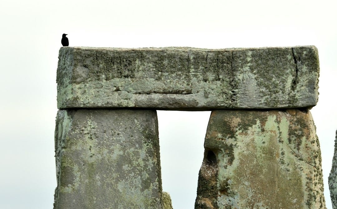 a stonehenge in a field of grass and rocks